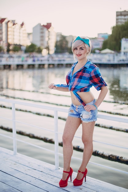 Blond girl posing on a white fence