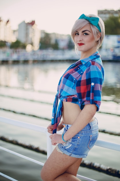 Blond girl posing on a white fence