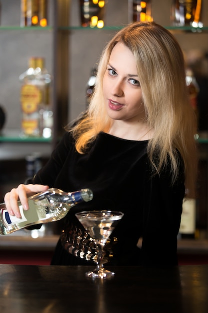 Blond girl pouring martini