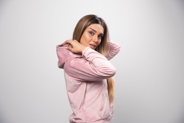 Free photo blond lady in pink sweatshirt posing in elegant and seductive manner.