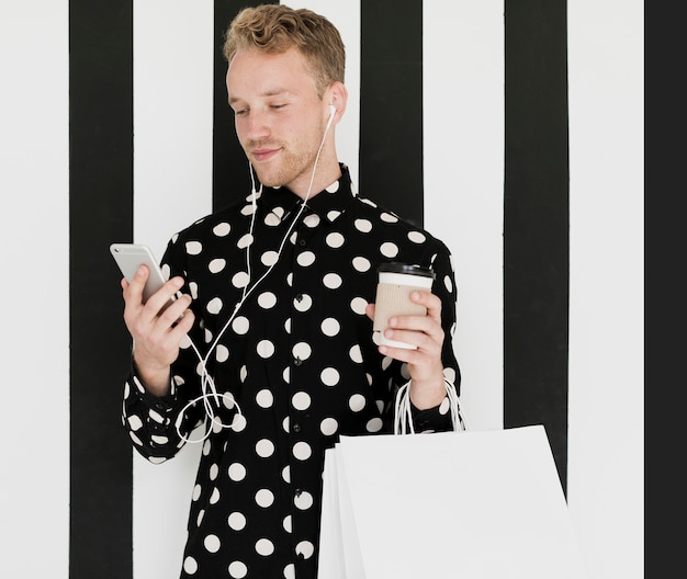 Blond man in shirt holding a coffee