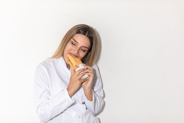Blond model biting a sandwich and enjoying .