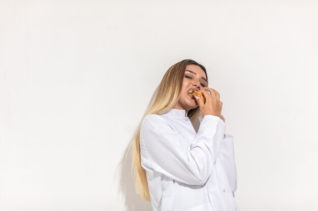 Blond model biting a sandwich and enjoying.