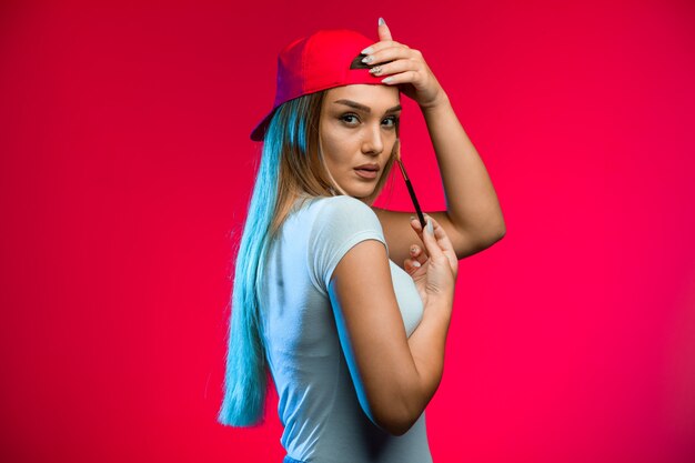 Blond model wearing red cap.