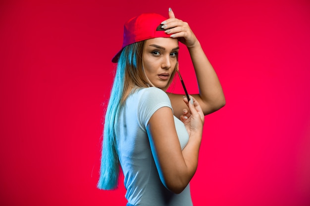Blond model wearing red cap.