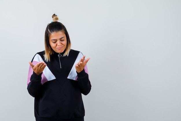 Blond woman being displeased with dumb question in black tracksuit and looking upset