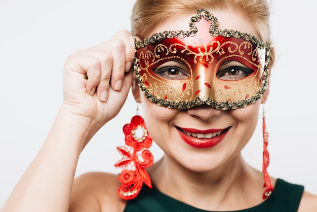 Free photo blond woman in bright red carnival mask