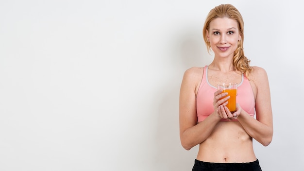 Free photo blond woman drinking orange juice