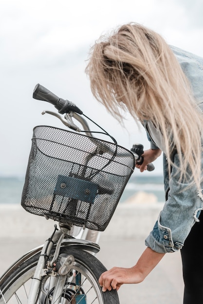 blond woman fixing her bike