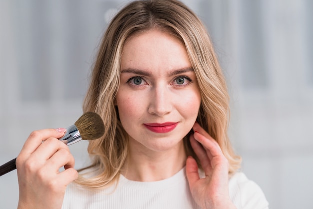 Blond woman having professional makeup