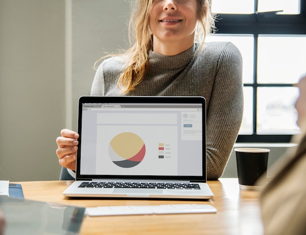 Foto gratuita donna bionda che indica lo schermo di un laptop