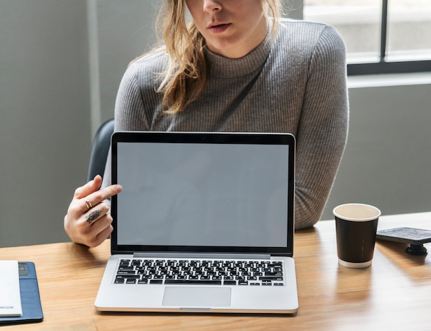 Blond woman pointing at a laptop screen