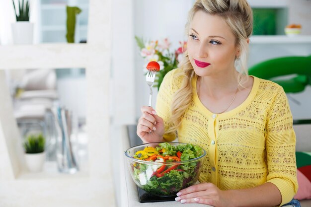 blond woman prepare salad at kitchen