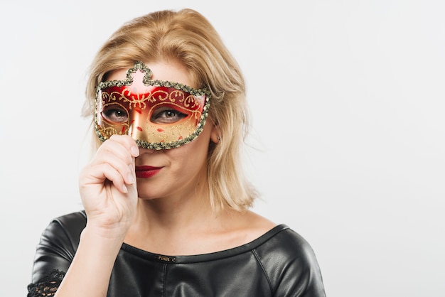 Foto gratuita donna bionda nella maschera di carnevale rosso