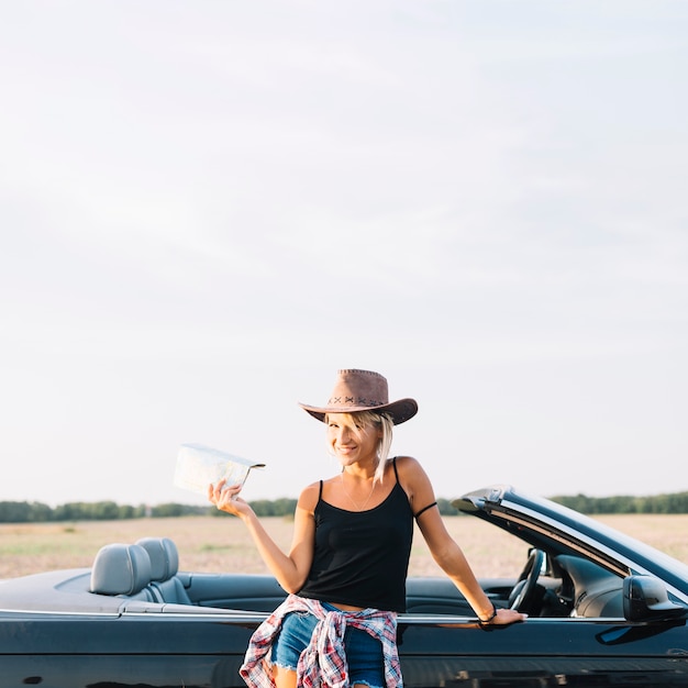 Foto gratuita donna bionda con mappa vicino cabriolet