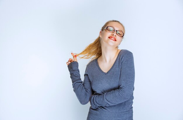 Blonde assistant with eyeglasses playing with her ponytail.