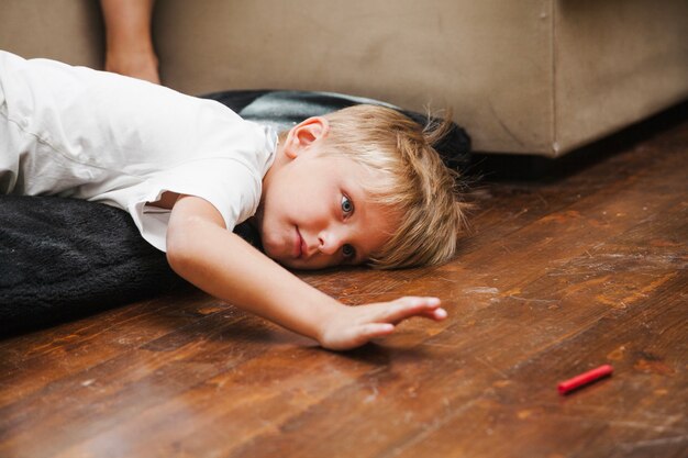 Blonde boy lying on pillows 