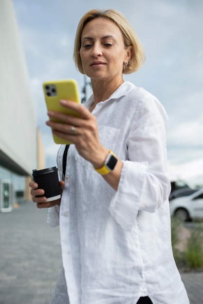 Блондинка бизнес-леди проверяет свой телефон