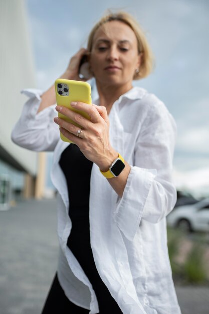 그녀의 전화를 확인 하는 금발의 비즈니스 우먼