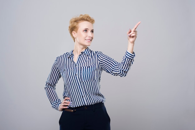 Blonde businesswoman pointing at copy space