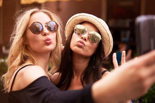 Free photo blonde and dark hair girls taking a selfie