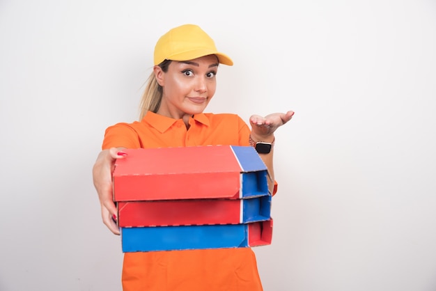 Blonde delivery woman holding pizza boxes on white space