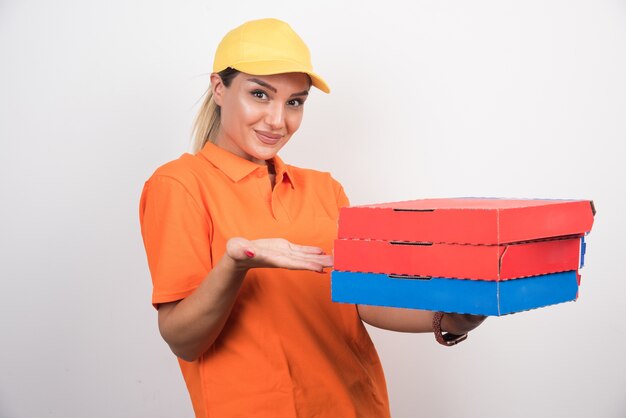 Blonde delivery woman holding pizza boxes.