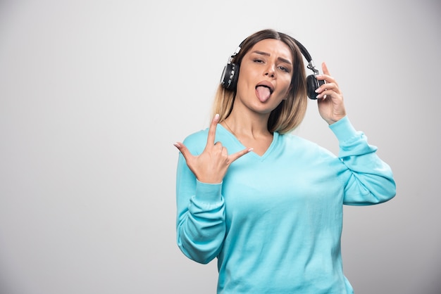Blonde dj girl posing with headphones in a positive manner.