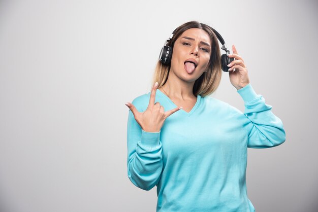 Blonde dj girl posing with headphones in a positive manner