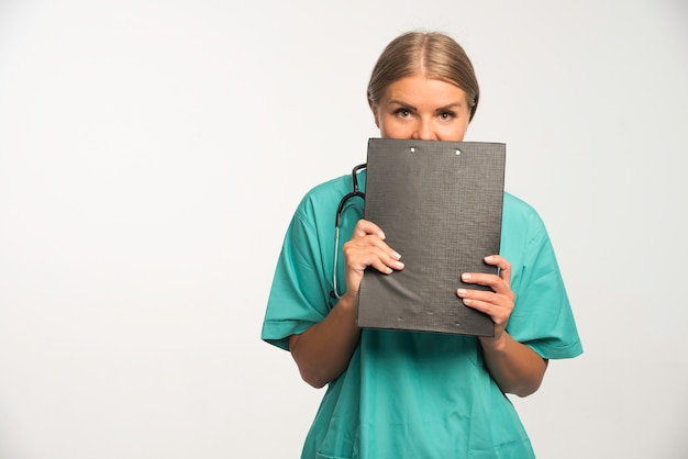 영수증 책을 들고 뒤에 숨어 파란색 유니폼에 금발 여성 의사.