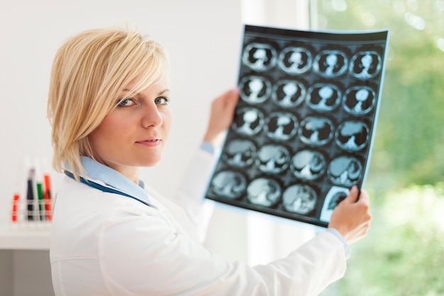 Blonde female doctor holding x-ray image