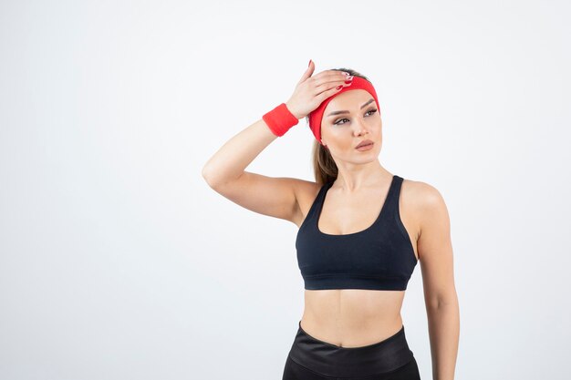 Blonde fit woman in black sportswear posing.  