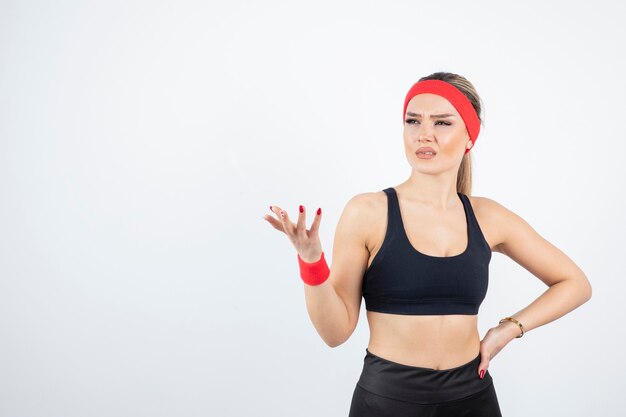 Blonde fit woman in black sportswear posing.  