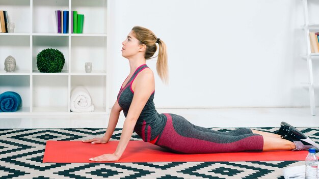 Blonde fitness young woman exercising in the living room