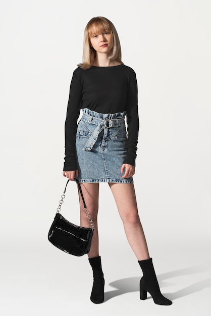 Блондинка в черном свитере и джинсовой юбке для фотосессии в зимней одежде