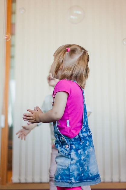 ブロンドの女の子は、石鹸の泡をキャッチ