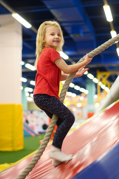 Blonde girl climbing a rope