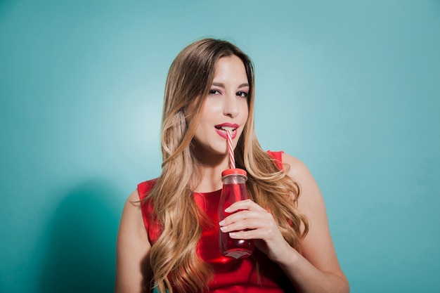 Blonde girl drinking red juice