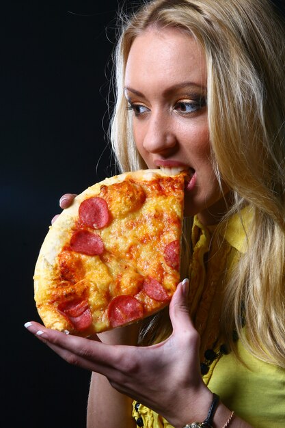 Blonde girl eats pizza