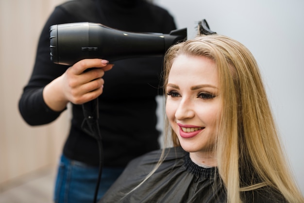 Free photo blonde girl getting her hair done