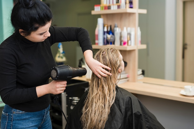 Free photo blonde girl getting her hair dried