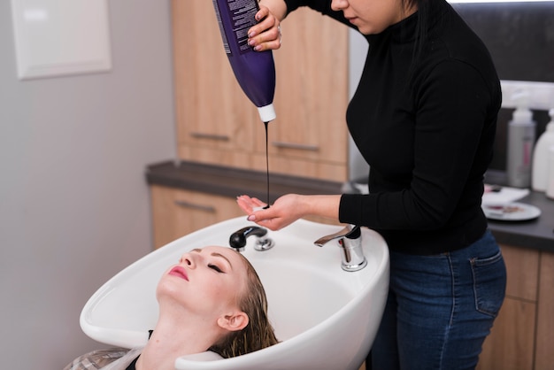 Free photo blonde girl getting her hair dyeing