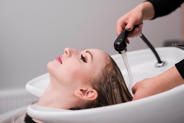 Blonde girl getting her hair washed