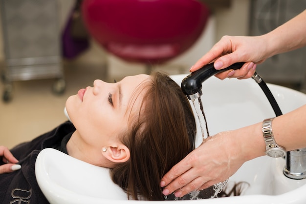 Free photo blonde girl getting her hair washed