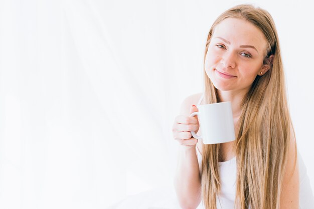 朝のコーヒーを飲んでいるブロンドの女の子