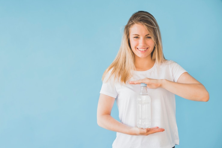 Free Photo blonde girl holding bottle of water