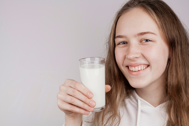 Блондинка держит стакан молока