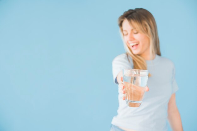 Blonde girl holding glass of water