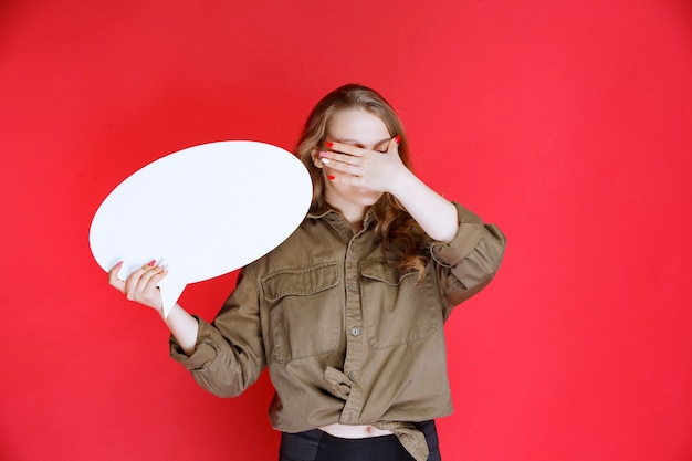 Ragazza bionda che tiene una scheda di progetto ovale e non si diverte.