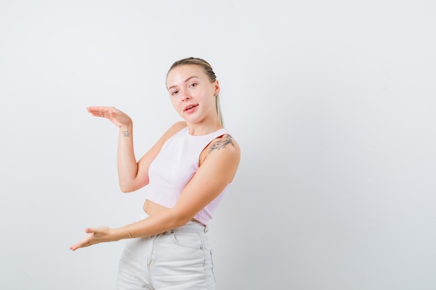 Blonde girl is explaining a big box on white background